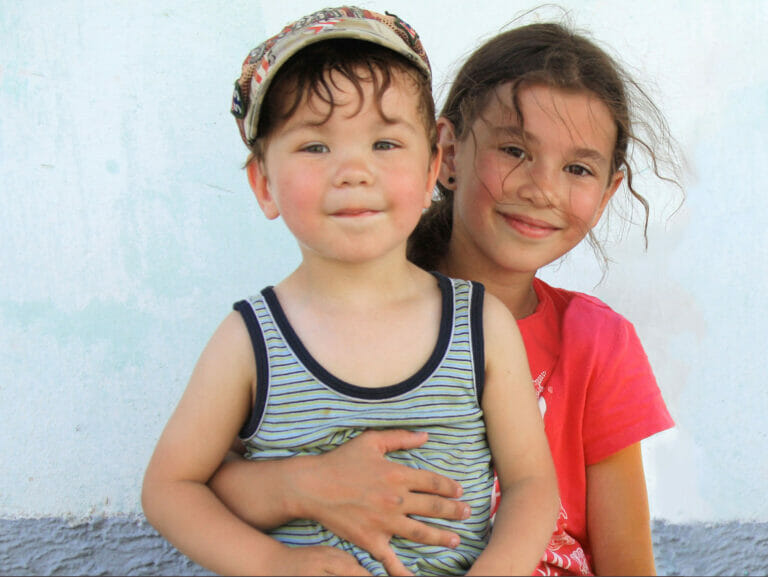 A boy and a girl posing for a picture.