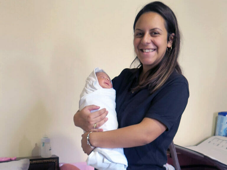 A woman holding a baby in her arms.