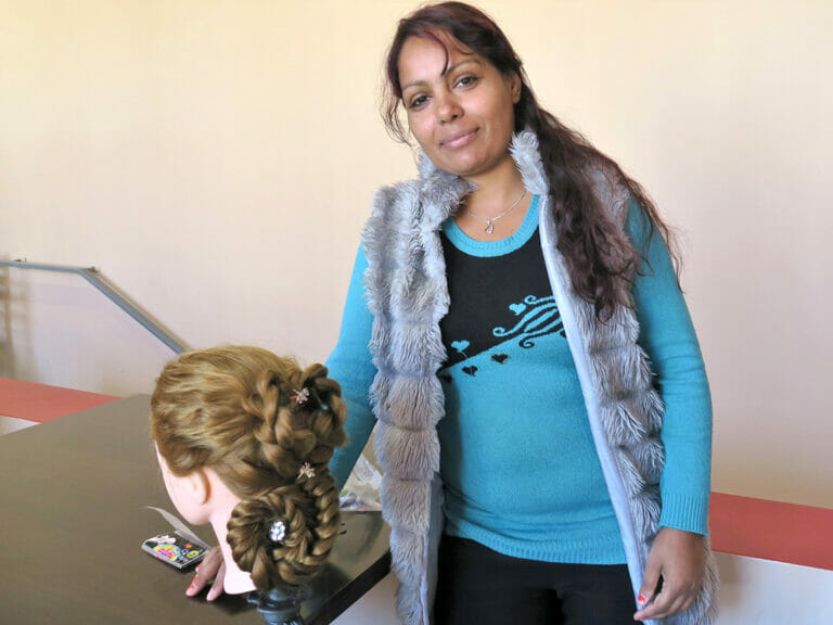 A woman standing next to a mannequin with hair.