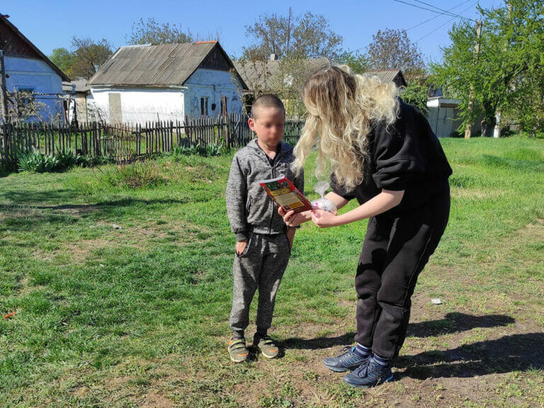 A woman is standing next to a boy in a grassy area, on a Mission Possible.