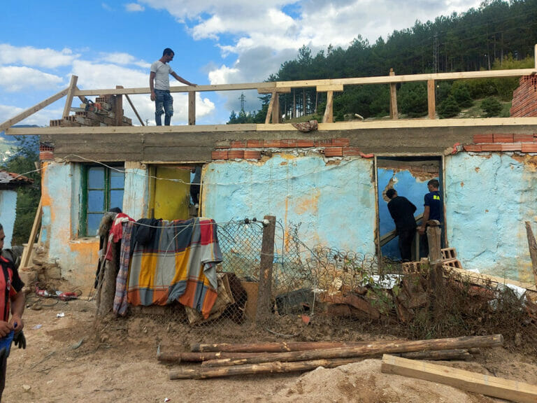 A group of people accomplishing a mission on the roof of a house.