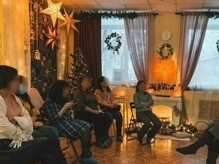 A group of people embracing the holiday spirit in a room adorned with Christmas decorations.
