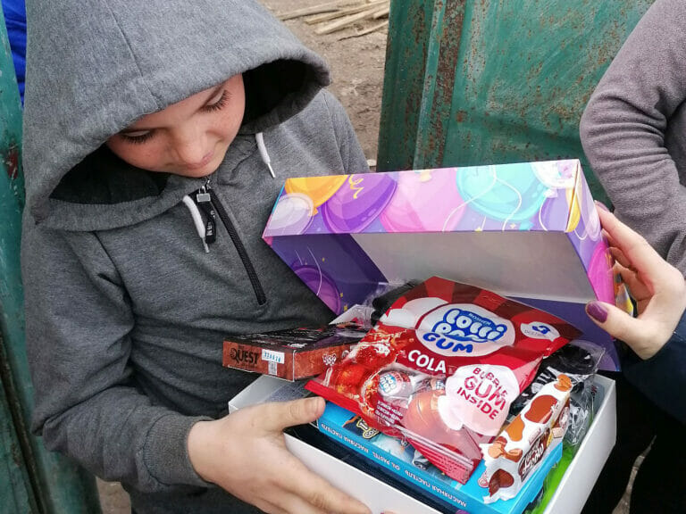 A boy successfully completes a Mission Possible by holding a box of candy.