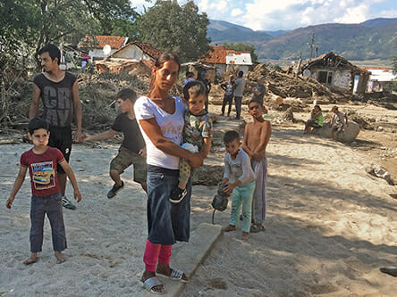 A group of people on a mission standing in the sand.