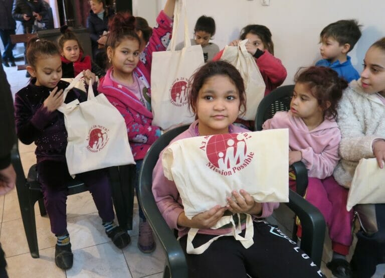 A group of children holding tote bags.