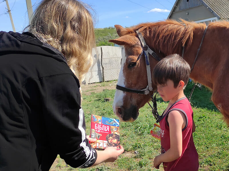 A woman is petting a brown horse.